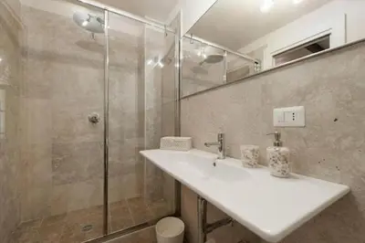 a bathroom with a white sink and a shower at Shabby Loft in Colosseum in Rome