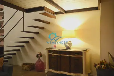 a living room with a stair wall with a lamp at Shabby Loft in Colosseum in Rome
