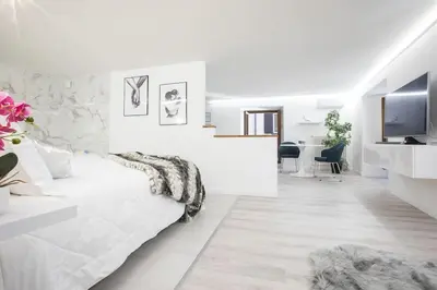 a white room with a bed and a television at My Piazza Navona Jacuzzi Suite - Top Collection in Rome