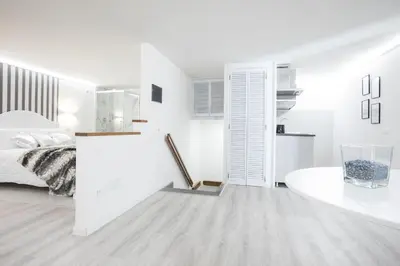 a white bedroom with a bed and a white table at My Piazza Navona Jacuzzi Suite - Top Collection in Rome