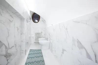 a bathroom with white marble walls and a toilet at My Piazza Navona Jacuzzi Suite - Top Collection in Rome