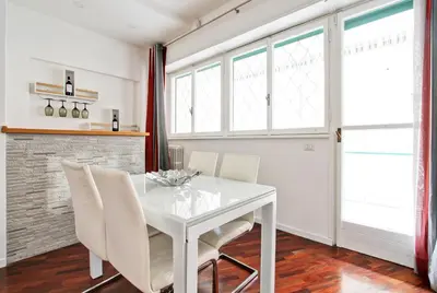 a white dining room with a white table and chairs at [Vaticano * * * * *] - Luxury Flat in Rome