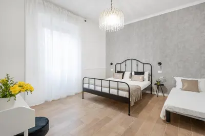 a bedroom with two beds and a chandelier at White flat Ground Floor in Rome