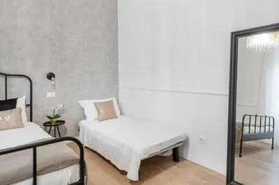 a bedroom with two beds and a mirror at White flat Ground Floor in Rome