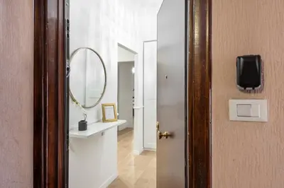 a hallway with a round mirror and a door at White flat Ground Floor in Rome