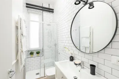 a white bathroom with a sink and a mirror at White flat Ground Floor in Rome