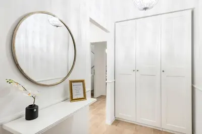 a dressing room with a mirror and a white cabinet at White flat Ground Floor in Rome