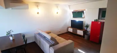 a living room with a couch and a television at Cosy penthouse loft with stunning view in Rome