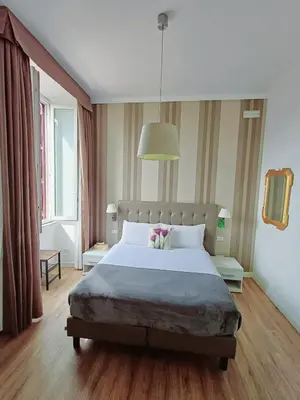 a bedroom with a large bed and a large window at MICHELANGELO SUITE ROMA GUEST HOUSE camere con vista sulle Terme di Diocleziano e sul Chiostro di Michelangelo in Rome