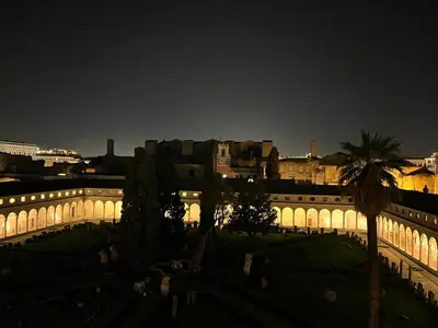 a view of a palm tree from an open window at MICHELANGELO SUITE ROMA GUEST HOUSE camere con vista sulle Terme di Diocleziano e sul Chiostro di Michelangelo in Rome