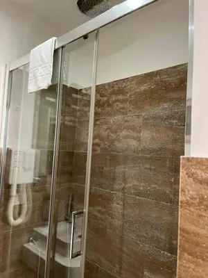 a shower with a glass door in a bathroom at MICHELANGELO SUITE ROMA GUEST HOUSE camere con vista sulle Terme di Diocleziano e sul Chiostro di Michelangelo in Rome