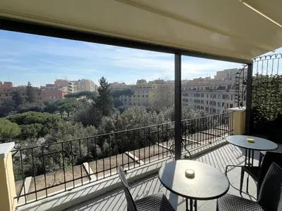 a balcony with tables and chairs and a view of a city at Re di Roma Rooftop in Rome