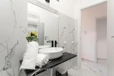 a white bathroom with a sink and a mirror at Re di Roma Rooftop in Rome