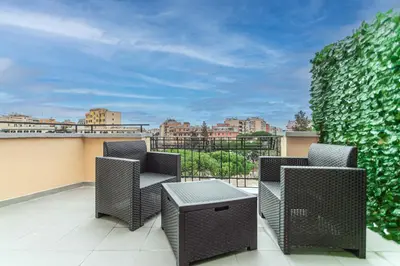 a patio with two chairs and a table on a balcony at Re di Roma Rooftop in Rome