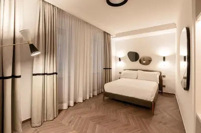 a bedroom with a white bed and curtains at Be Mate Colosseo in Rome