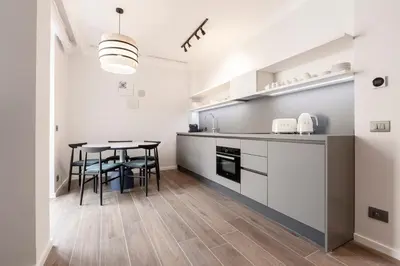 a kitchen with a table and chairs in a room at Be Mate Colosseo in Rome