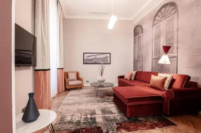 a living room with a red couch and a table at Be Mate Piazza Navona in Rome