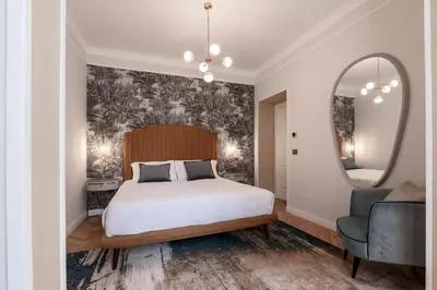 a bedroom with a bed and a mirror and a chair at Be Mate Castel Sant'Angelo in Rome
