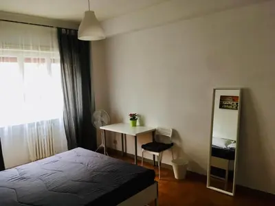 a bedroom with a bed and a table and a mirror at La mia casa di Roma in Rome