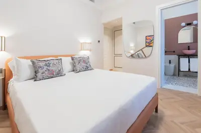 a bedroom with a large white bed with a mirror at Be Mate Trastevere I in Rome