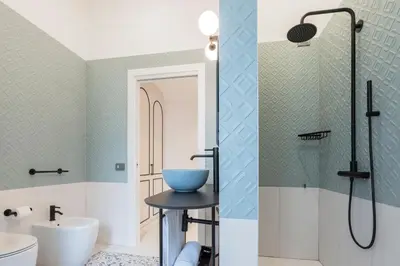 a bathroom with a shower and a blue bowl on a stool at Be Mate Trastevere I in Rome