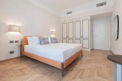a white bedroom with a large bed and a table at Be Mate Trastevere I in Rome