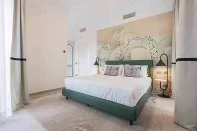 a bedroom with a green bed and a wall with flowers at Be Mate Trastevere III in Rome