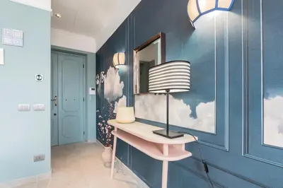 a room with a blue wall with a lamp and a mirror at Be Mate Trastevere III in Rome