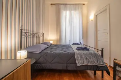 a bedroom with a bed and a large window at Praty Rooms in Rome