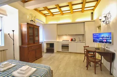 a kitchen and dining room with a table and a television at Cozy Studio Flat in Trastevere by Yourhost in Rome