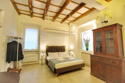 a bedroom with a bed and a cabinet and a table at Cozy Studio Flat in Trastevere by Yourhost in Rome