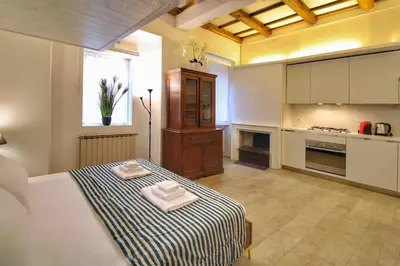 a large room with a bed and a kitchen at Cozy Studio Flat in Trastevere by Yourhost in Rome