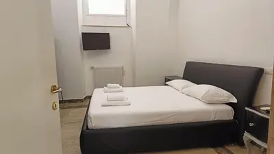 a bed with white sheets and pillows in a room at Sanniti' Home in Rome