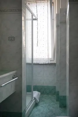 a bathroom with a glass shower with a window at Vatican Walls Apartment in Rome