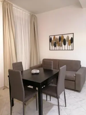 a dining room table with chairs and a couch at Vatican Walls Apartment in Rome