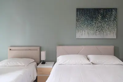 a bedroom with two beds and a painting on the wall at Vatican Walls Apartment in Rome