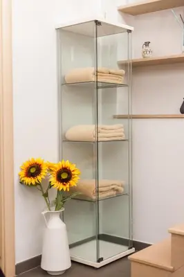 a glass shelf in a kitchen with a vase with sunflowers at Attic Vatican Flat - San Pietro in Rome