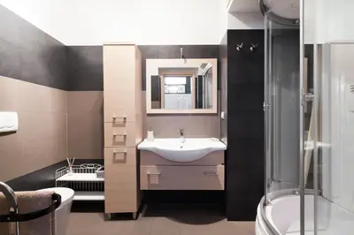 a bathroom with a sink and a mirror and a shower at Attic Vatican Flat - San Pietro in Rome
