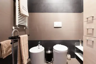 a bathroom with two toilets and a sink in it at Attic Vatican Flat - San Pietro in Rome