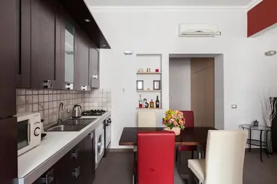 a kitchen with a sink and a red stool at Attic Vatican Flat - San Pietro in Rome