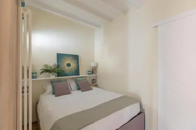 a bedroom with a bed in a white room at iFlat The Heart of Monti in Rome