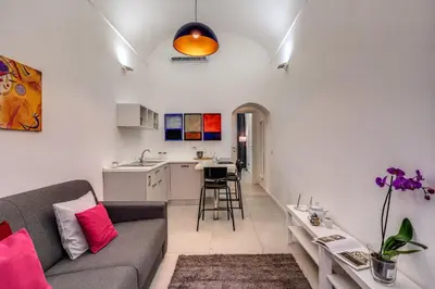a living room with a couch and a kitchen at Studio Artis Piazza di Spagna in Rome