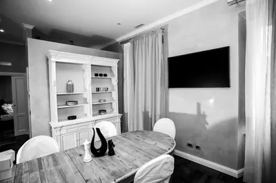 a dining room with a table with chairs and a television at FORNACI 48 GUEST HOUSE in Rome