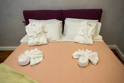 a bed with white towels and slippers on it at FORNACI 48 GUEST HOUSE in Rome