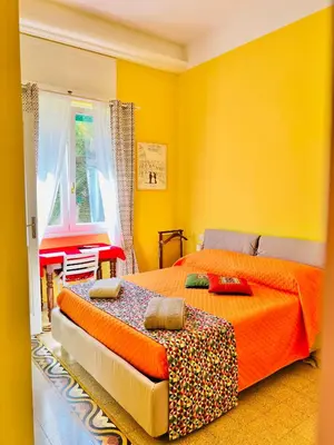 a yellow bedroom with two beds and a window at Antonioni's Apartment Trastevere in Rome