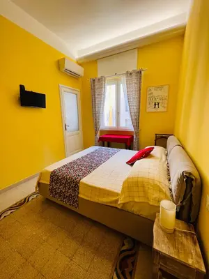 a bedroom with a bed in a yellow room at Antonioni's Apartment Trastevere in Rome
