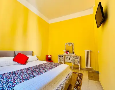 a yellow bedroom with a bed and a mirror at Antonioni's Apartment Trastevere in Rome