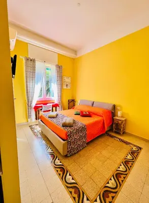a yellow bedroom with a bed and a couch at Antonioni's Apartment Trastevere in Rome