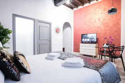 a bedroom with a white bed and a tv at Cozy Studio Campo dè Fiori in Rome