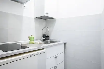 a kitchen with white cabinets and a sink at Cozy Studio Campo dè Fiori in Rome